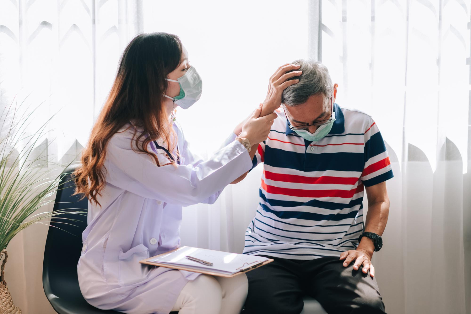 A doctor examines an elderly man in a headache specialist clinic, discussing migraine symptoms and treatment options.