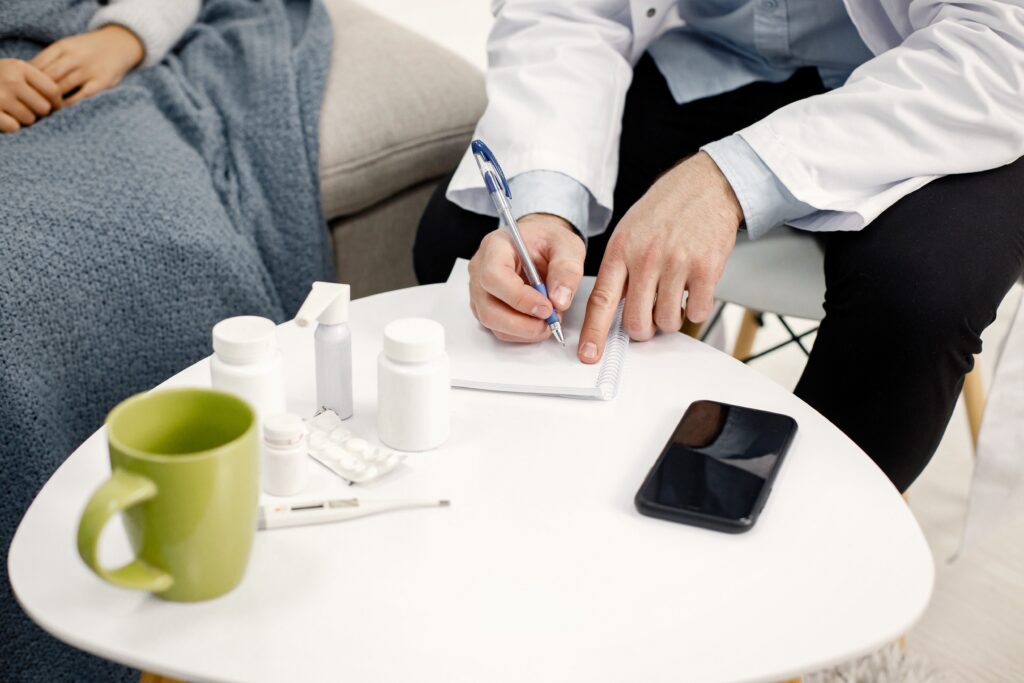 A physician writes on paper while sitting on a couch, exploring the effectiveness of TMS versus antidepressant medications for depression.